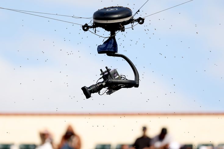 A drone surrounded by a swarm of bees flying over the pitch at Kwaraa Stadium during the football match.