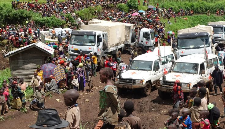 Crowded gathering in Congo with Red Cross staff assisting people.