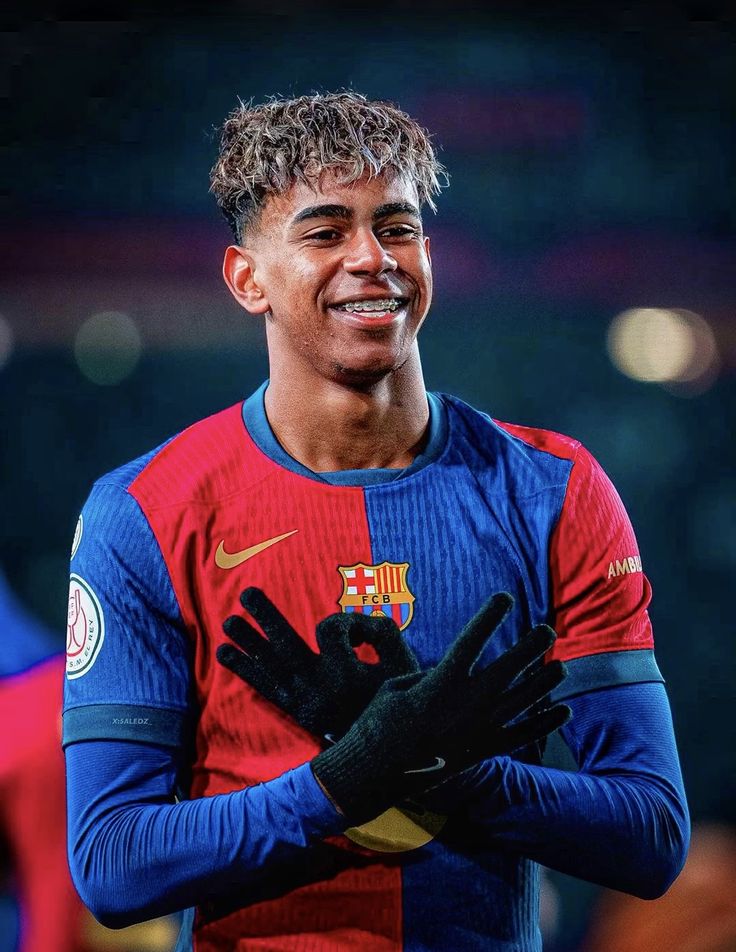Young Spanish footballer Lamine Yamal posing in FC Barcelona jersey during a match.