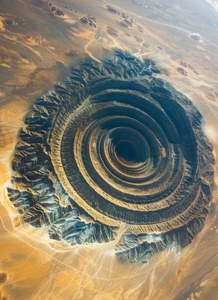 Satellite view of the Eye of the Sahara in Mauritania, showing concentric rings of rock formations in the desert.