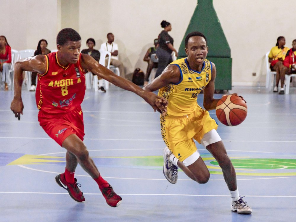 Rwandan U16 basketball player dribbling past an Angolan defender