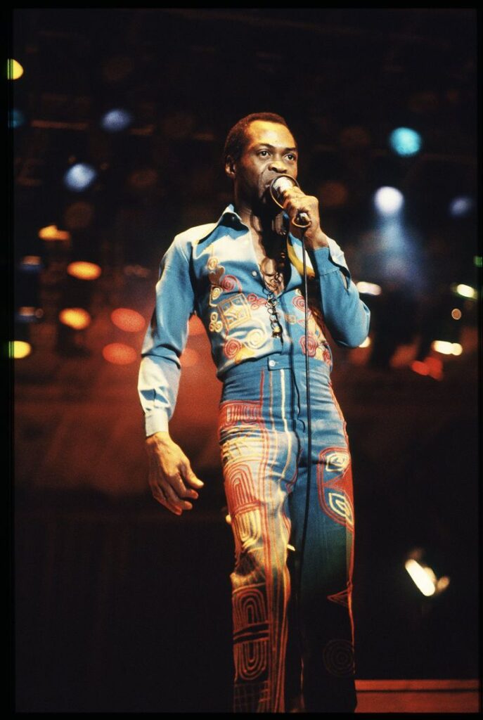 Fela Kuti leading a large crowd at Afrika Shrine, showcasing Afrobeat rhythms
