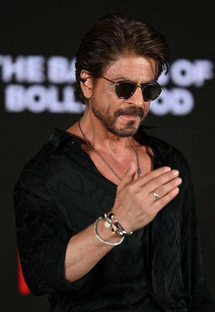 Shah Rukh Khan, iconic Indian actor, celebrating his achievement as the first Bollywood star to officially become a billionaire.